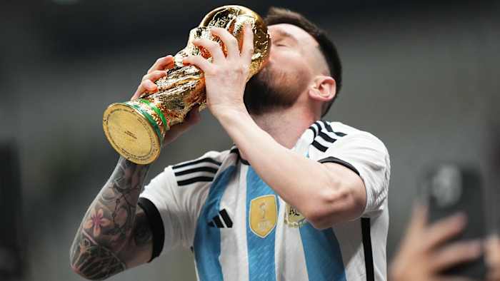Lionel Messi kisses the World Cup trophy